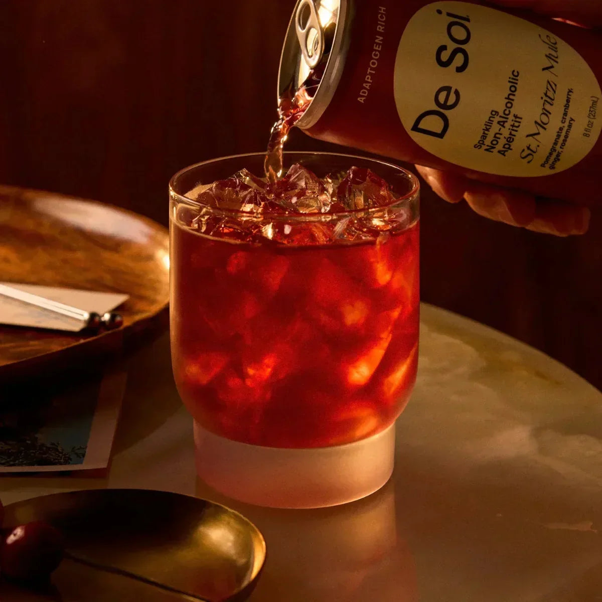 Pouring De Soi St. Moritz Mule non-alcoholic aperitif over ice for a holiday drink.