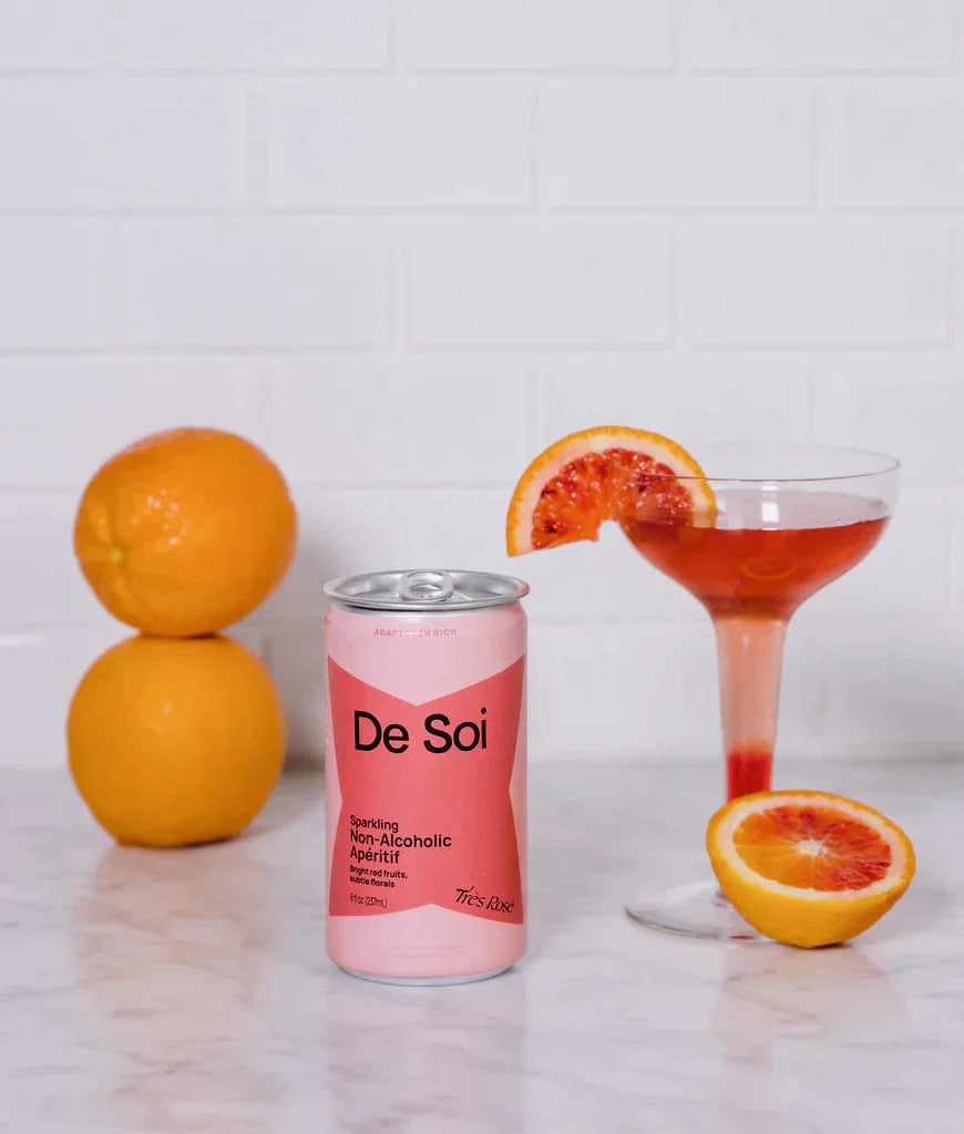 De Soi Très Rosé can beside a blood orange mocktail in a coupe glass.