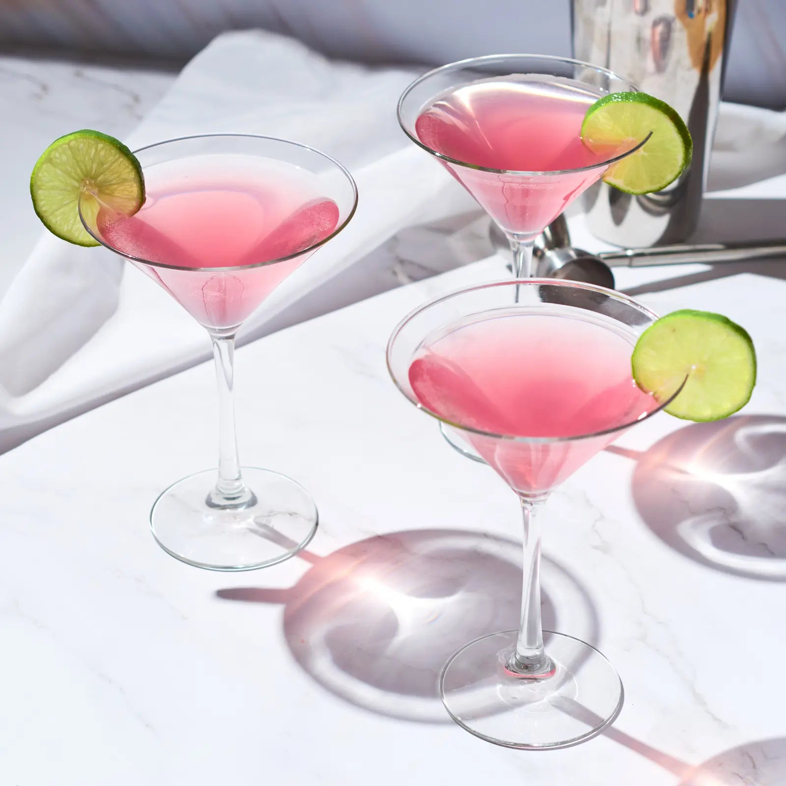 Cosmopolitan mocktails garnished with lime slices served in elegant glasses on a marble surface