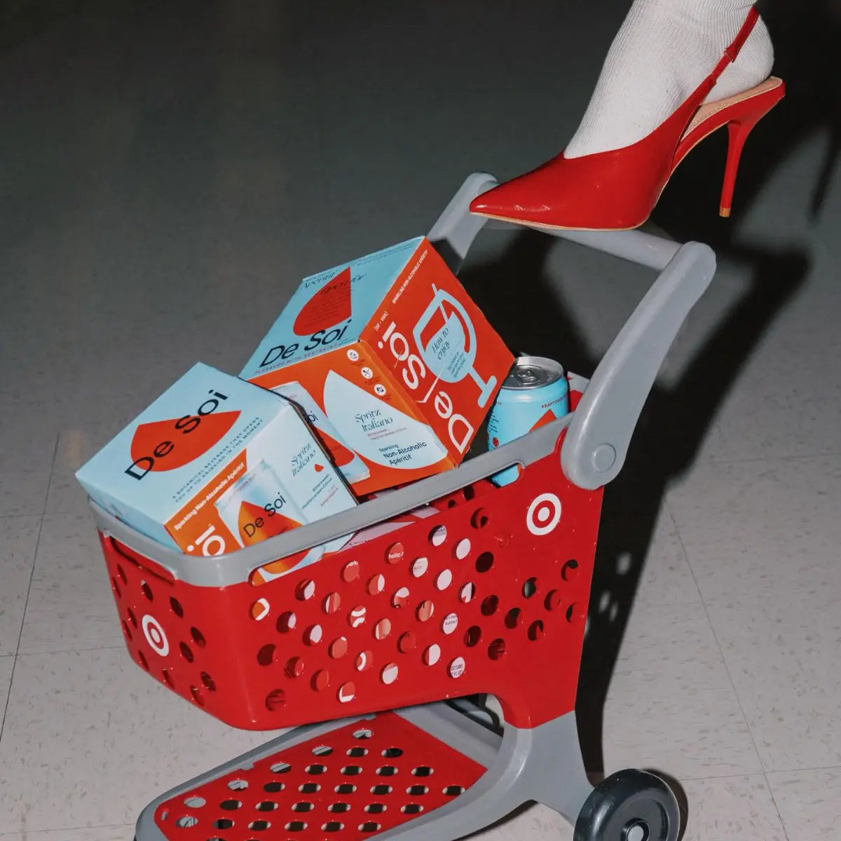 Shopping cart filled with De Soi non-alcoholic cocktail boxes and cans in colorful varieties