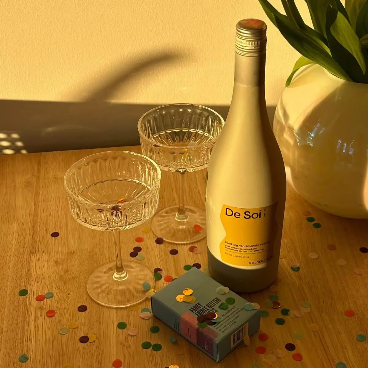  Best alcohol-free apéritifs like De Soi Golden Hour are showcased with coupe glasses and confetti in warm golden sunlight.
