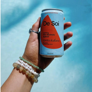 Dry January benefits highlighted with a refreshing can of De Soi non-alcoholic aperitif held against a bright blue background.