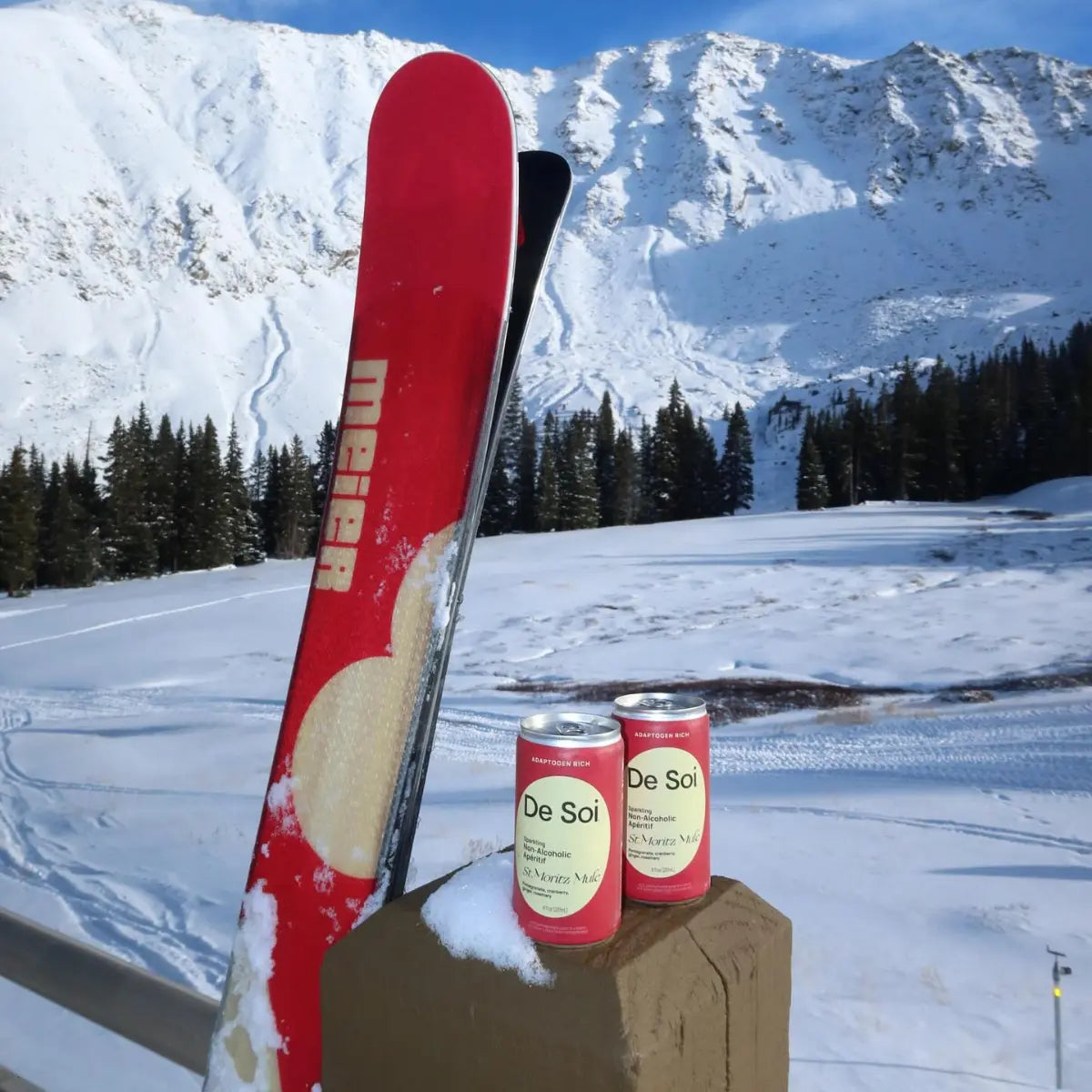 Functional drinks without alcohol displayed with two cans of De Soi St. Moritz Mule against a snowy mountain backdrop