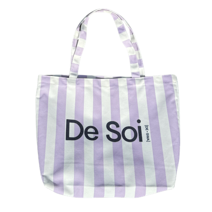 Lilac and white striped canvas De Soi tote bag with navy logo and handles.